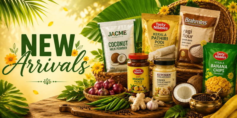 A promotional collage for Tasty Nambass and Jacme food products, featuring coconut milk powder, Kerala pathiri podi, ragi flour, banana chips, mango chutney, and coconut, styled with tropical leaves, coconuts, garlic, and red onions on a wooden table with a 'NEW Arrivals' banner.